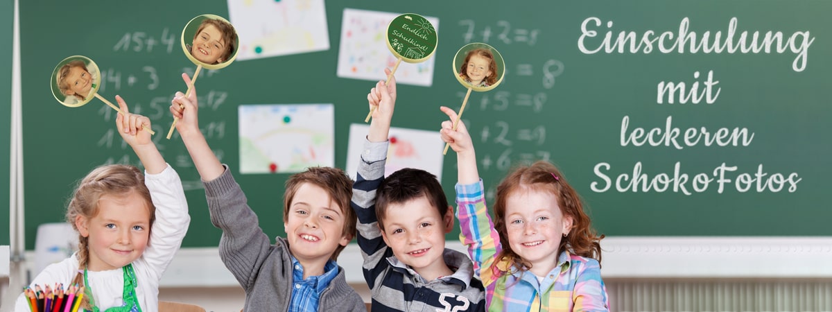 Personalisierte Schokolade zur Einschulung 2024. Kinder halten gedruckte Schokoladen-Lollis in der Luft. Im Hntergrund eine Tafel mit dem Schriftzug "Einschulung mit leckeren SchokoFotos".