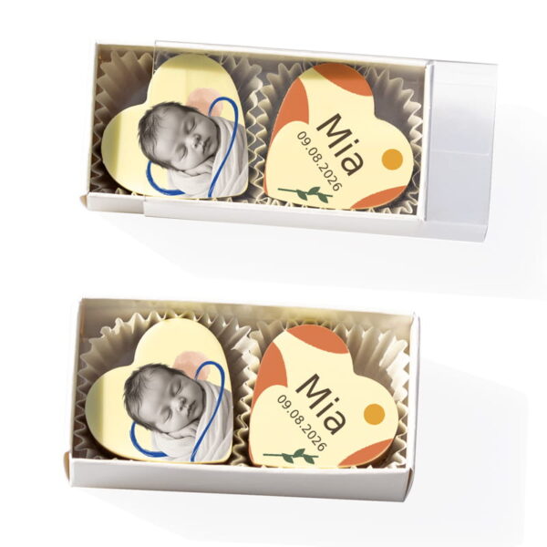 2 Herzpralinen zur Taufe in einer Stange mit Babyfoto sowie Name Mia und Datum in orangefarbener Gestaltung